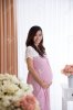 45151062-happy-pregnant-asian-woman-in-pink-dress-touching-her-big-belly.jpg